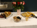refreshments: centerpiece of roses, trail mix, macedamia nuts, crackers, grapes, oatmeal raisin cookies, scones